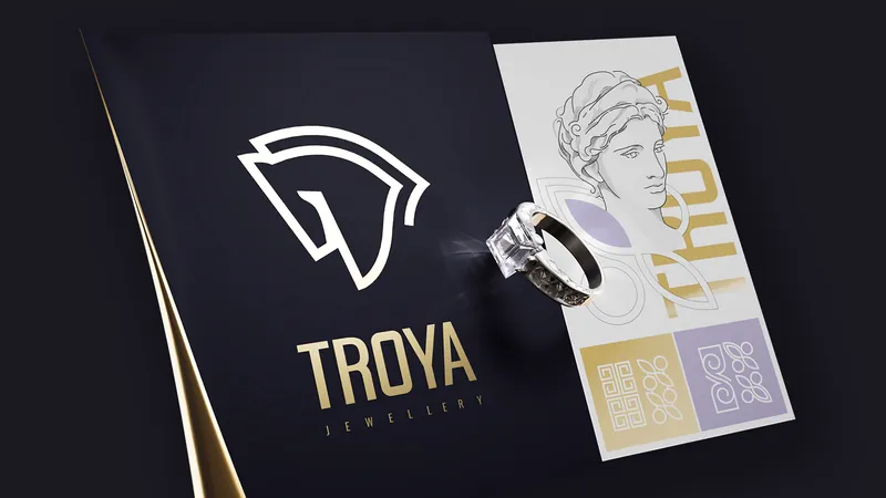 Troya Jewellery horse-head logo in gold on a black brand book with a ring