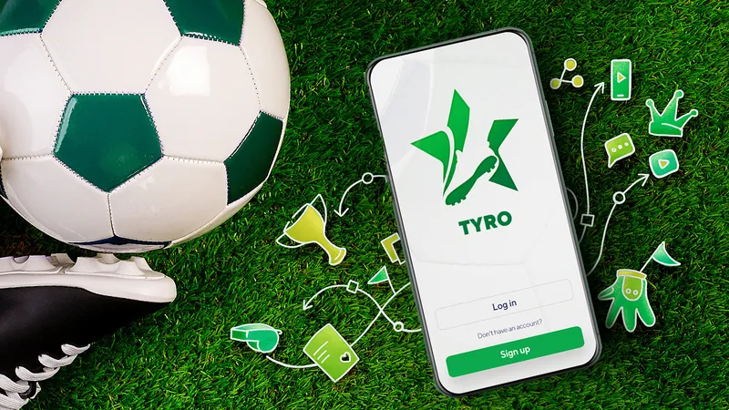 Tyro app on a phone lying on grass next to a football