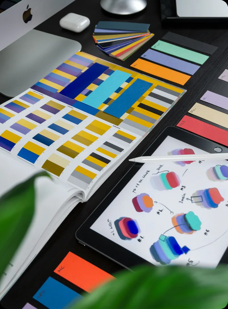 Colour swatch cards and printed brand guidelines spread across a desk