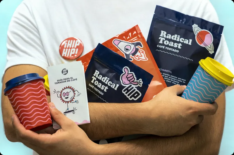 Arms holding Radical Toast coffee bags, Hip Hip badges and wavy-striped cups