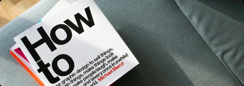 Michael Bierut’s “How to” book lying on a grey-green sofa